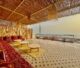 Exterior view of Tamraght surf house Morocco at golden hour — whitewashed walls, rooftop terrace, Atlantic Ocean in background