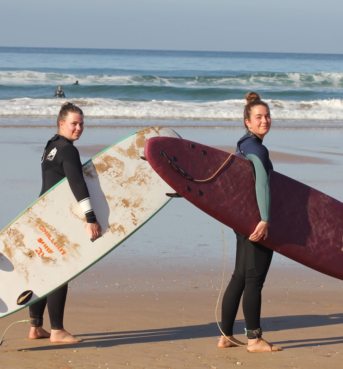 Surfers walking toward the ocean at Taghazout with boards — all-inclusive Morocco surf package from Surf Hostels Morocco