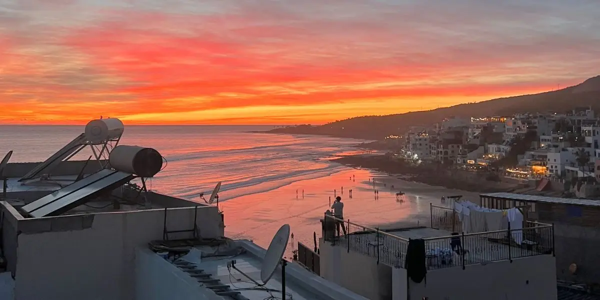 Surfers walking towards the ocean at Taghazout surf camp Morocco during sunset.